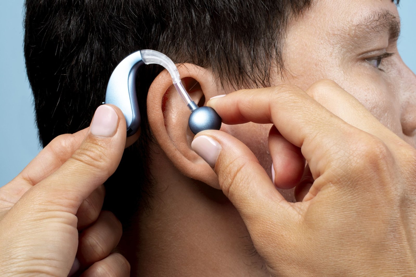 Modern digital hearing aids shown beside an audiologist's fitting tools